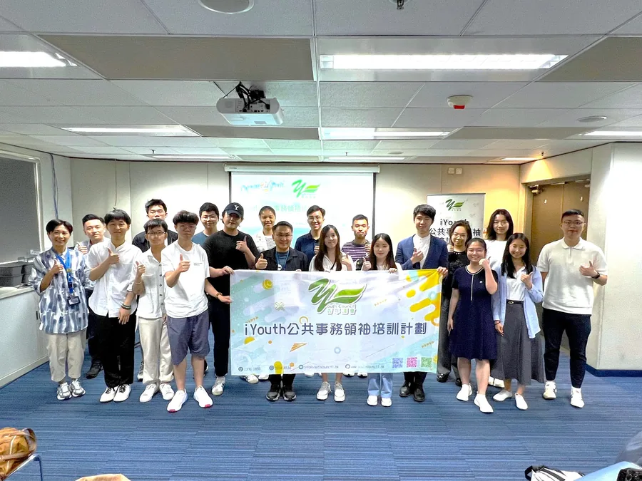 iYouth 學員與海洋公園行政總裁黃嗣輝先生在室內持計劃橫額合照。